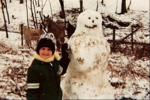 Adrian with snowman as a kid