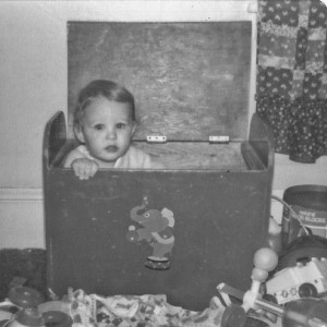 Adrian in his toy box